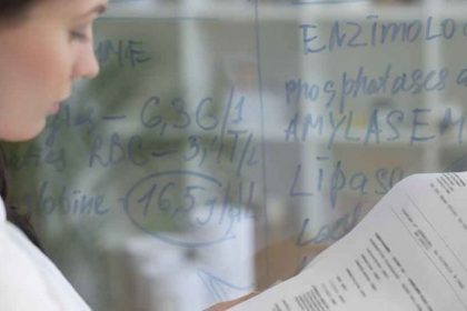 A scientist reviews assessment data in a laboratory, relating to vet compliance.