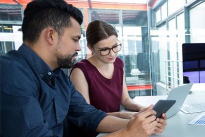 Business professionals analyze data on a tablet, reflecting RTO experiences with ASQA.