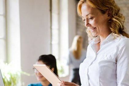 A businesswoman reviews information on a tablet, relating to changes in the vet sector.