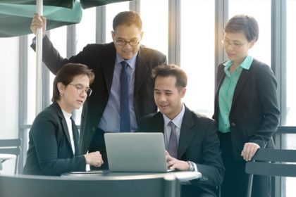 A business team collaborates on a laptop, representing international engagement in the vet sector.