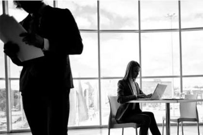 A businesswoman uses a laptop in an office setting, highlighting concerns about VET funding.