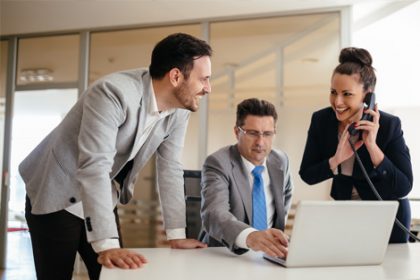 A business team collaborates on a laptop, highlighting the importance of copyright in vet sector content.