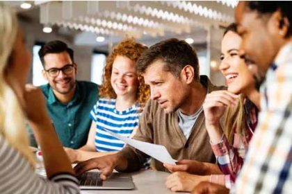 A business team discusses ideas during an office collaboration, highlighting positive vet sector outcomes.