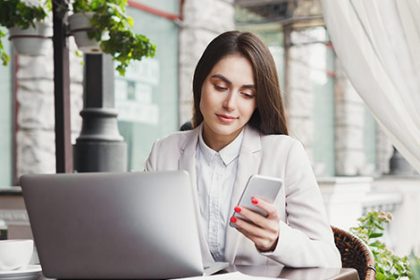 A business professional uses a laptop and smartphone, illustrating modern vet compliance processes.