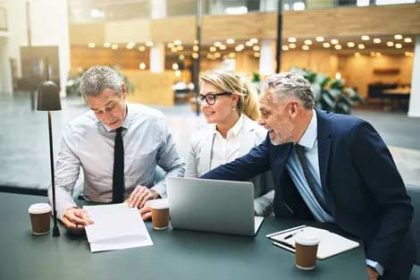 A business team discusses vet compliance during an office meeting.