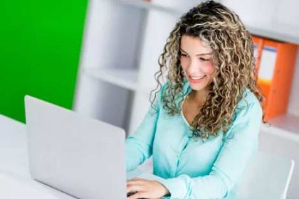 A businesswoman uses a laptop while working, demonstrating reasonable adjustments in vet training.