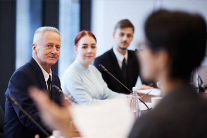 A business meeting shows professionals discussing vet sector updates.