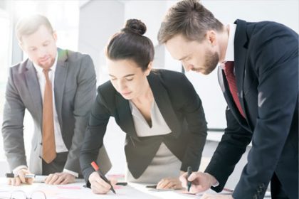A business team reviews architectural plans, demonstrating effective vet compliance processes.