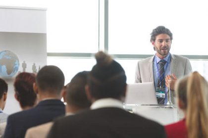 A speaker presents to an engaged audience during a business presentation about the vet sector.
