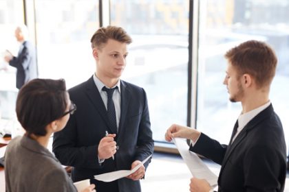 Business people collaborate on vet sector documents in a modern office.