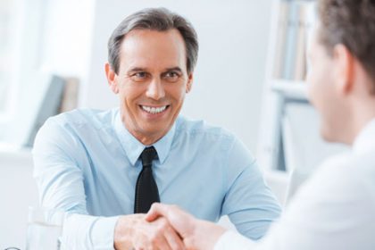 A businessman shakes hands with a candidate during a job interview, highlighting successful vet sector outcomes.