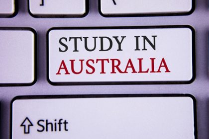 A keyboard shows 'Study in Australia', reflecting concerns about international student return to Australia amid the vet.
