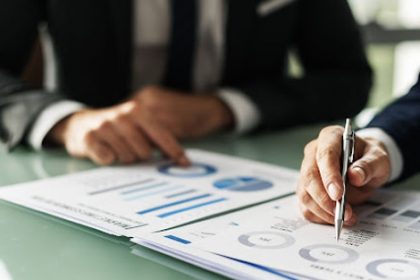 A business meeting focuses on financial data and charts relevant to the vet sector.