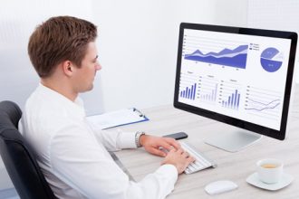 A business professional analyses vet sector data on a computer, reviewing charts and graphs.
