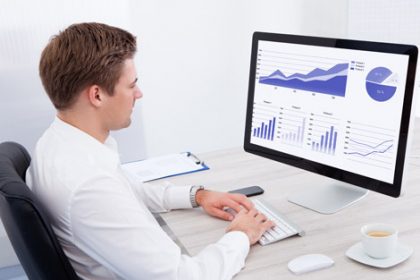 A business professional analyses vet sector data on a computer, reviewing charts and graphs.