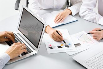A team reviews assessment resources and data charts, crucial for vet compliance.