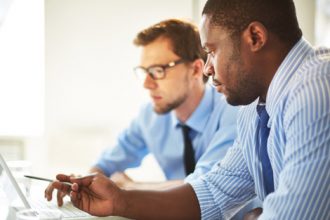 Business professionals assessing risks together, crucial for effective VET compliance.
