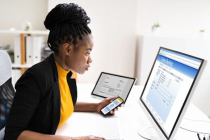 A woman uses multiple devices for online banking, highlighting the need for authentic assessment in vet sector learning.