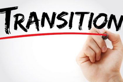 A hand writes 'transition' on paper, illustrating the importance of transition planning in the vet sector.