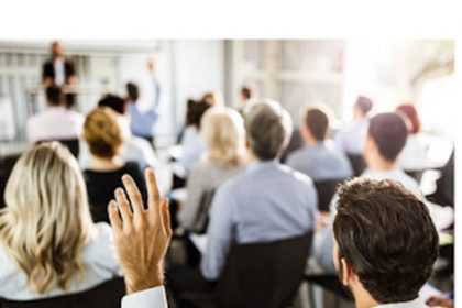 An engaged audience participates in a business seminar discussing high-quality VET delivery.