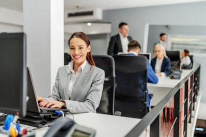 A businesswoman uses a laptop in an office, addressing common challenges in the vet sector.