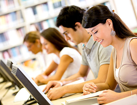 Students researching with computers and books, demonstrating effective e-learning.