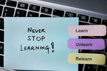 A laptop screen shows a message about lifelong learning, highlighting the importance of upskilling.
