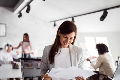 A businesswoman reviews training documents in an office, highlighting different assessment strategies.