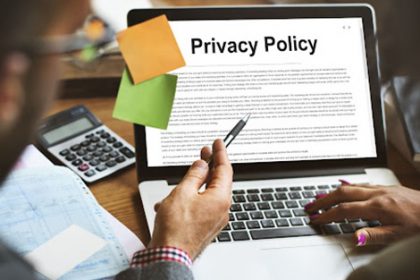 A laptop displays a privacy policy document with office supplies, relevant to vet compliance.