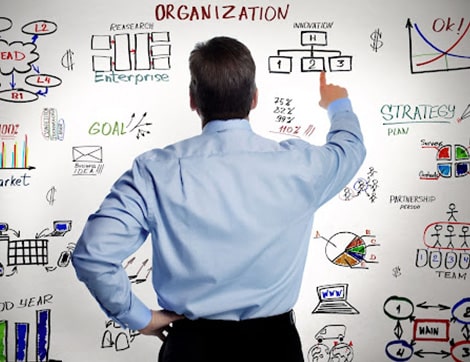 A businessman reviews a business strategy flowchart, highlighting challenges for RTO training.