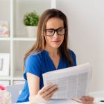 A woman reads a newspaper, representing current vet sector news and updates.