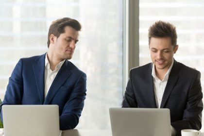 Businessmen collaborating on laptops highlights the need for varied vet training resources.