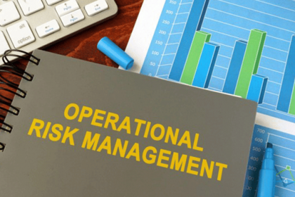 A notebook displays operational risk management concepts with charts and office supplies.